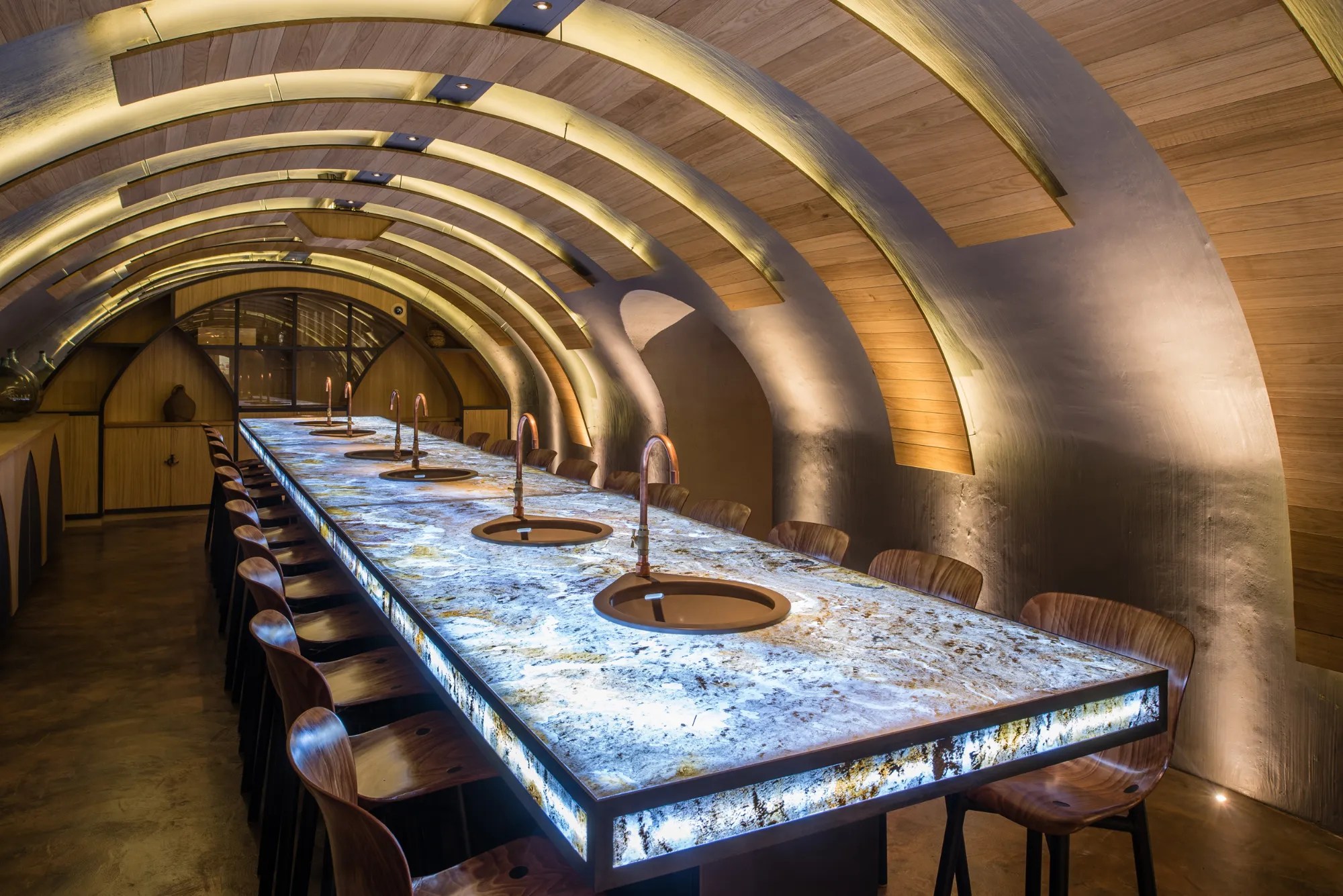 Les Caves du Louvre à Paris : salle voûtée en bois avec une grande table lumineuse